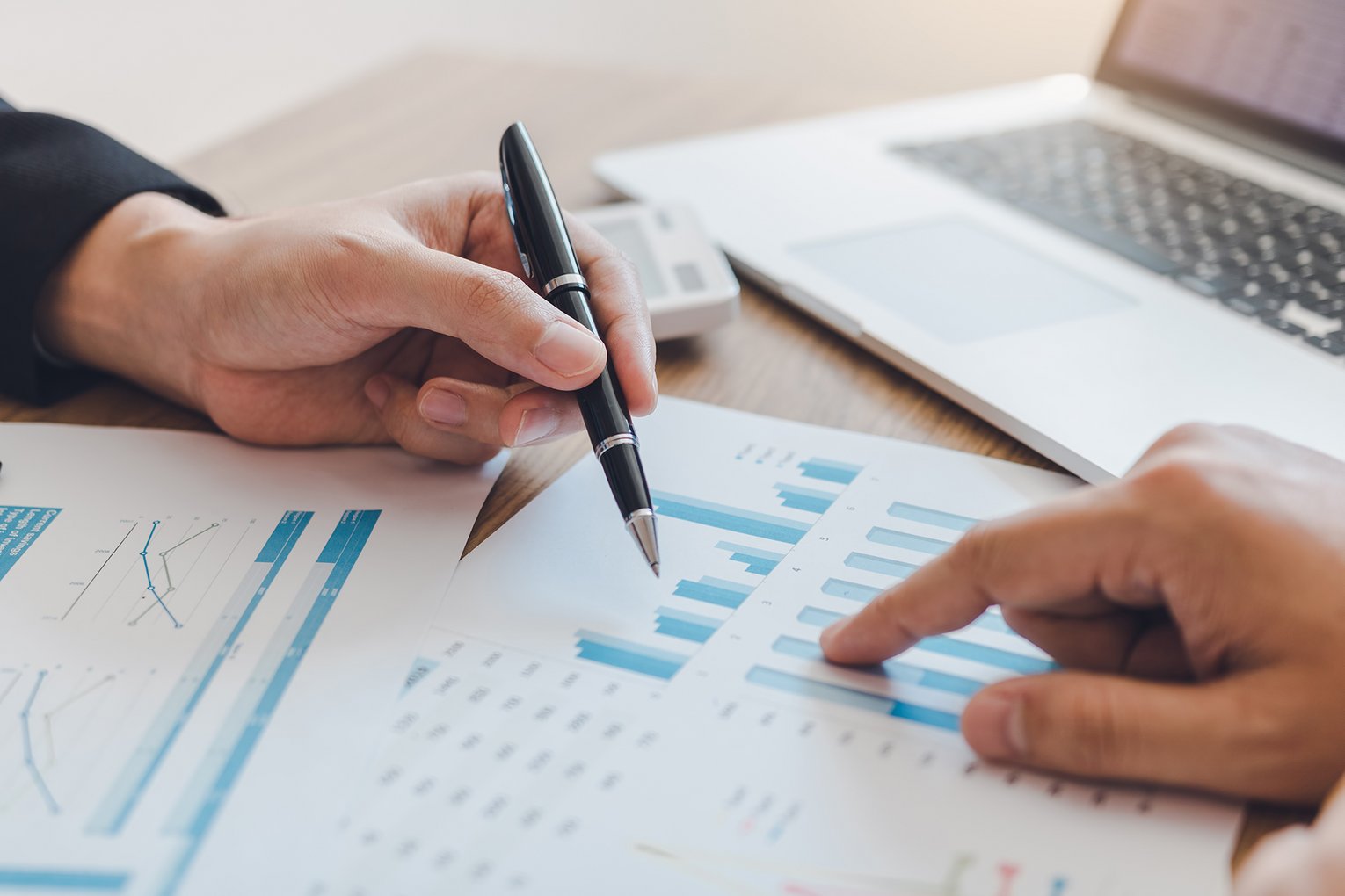 Analyse von Finanzdaten mit Diagrammen und Laptop im Hintergrund